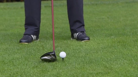 Close up of a golf ball on a tee being hit by a driver Stock Footage 85168757