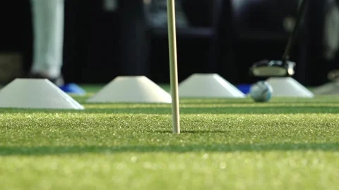 Close-up of a golfer practicing putting on artificial turf with a golf club and Stock Footage 332133865