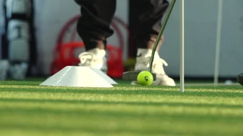 Close-up of a golfer practicing putting on artificial turf with a golf club and Stock Footage 332507356