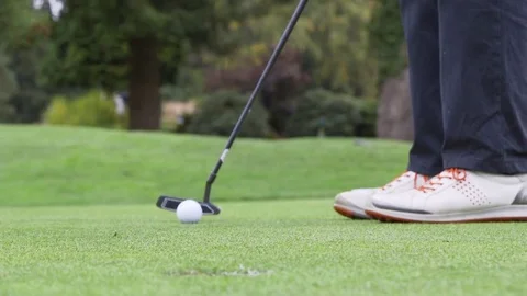 Close up of a golfer putting a golf ball into the hole Stock Footage 85169130