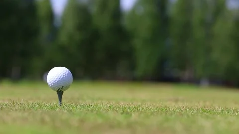 Close-up of a golfer's hand putting the ball on a stand, putter on the Video stock 166523133