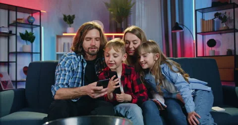 Close up of good-looking smiling friendly modern family which relaxing on the Stock Footage 158046739