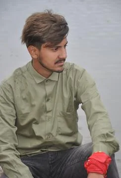 Close up of a good looking young guy looking sideways while sitting  Stock-Fotos