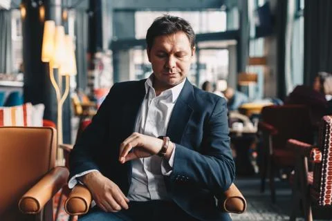 Close-up of good looking young man sitting in a cafe bar during a break from  Stock Photos