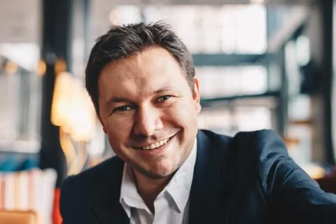 Close-up of good looking young man making a selfie in a cafe bar during a bre Stock Photos