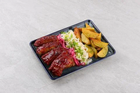 Close up Gourmet Main Dish with Grilled Pork Rib and Fried Potatoes on White Foto stock