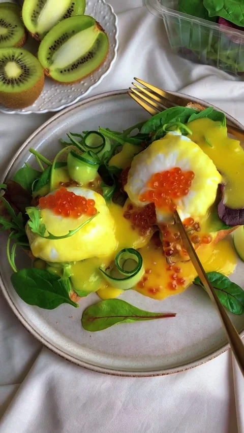 Close-up of a gourmet poached egg breakfast with salmon roe and fresh greens Video stock 344852102