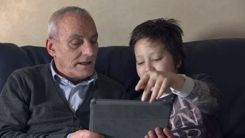 Close up on  grandfather with grandson using tablet on couch Stock Footage 74693371