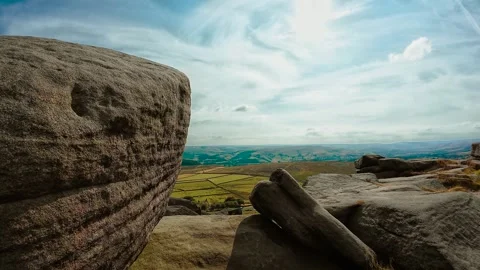 Close granite boulder beside panoramic rural valley under bright cloudscape Stock Footage 341569205