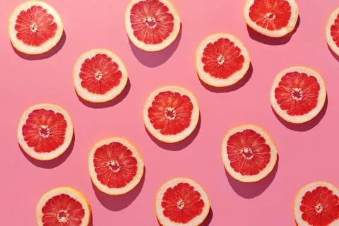 Close up grapefruit cut slice on pink background Photos