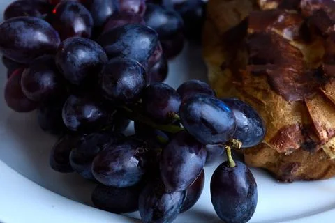 Close-up of grapes and eclair pastry for sweet rustic dessert photo Stock Photos