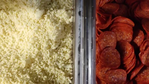 Close-Up of Grated Cheese and Sliced Pepperoni at Food Counter Stock Footage 346818042