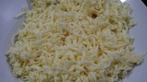 Close-up of grated parmesan cheese on a plate on the table to prepare homemade Stock Footage 164579855