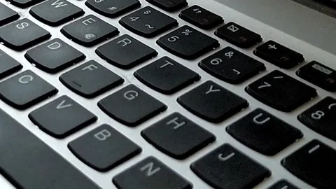 Close-up of gray computer keyboard with black keys Vídeo Stock 140328831