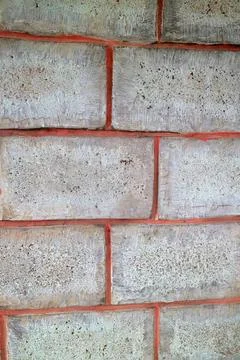 Close-up of gray concrete brick wall with red mortar lines Stock Photos