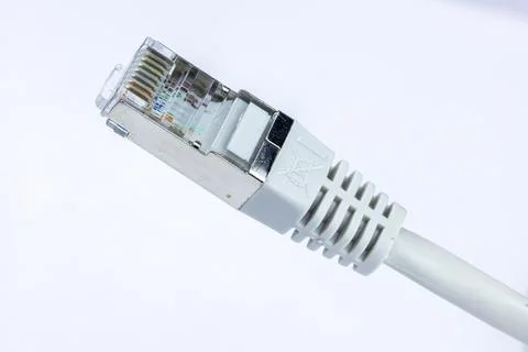 Close-up of a gray Ethernet cable connector against a white background.  Th.. Stock Photos