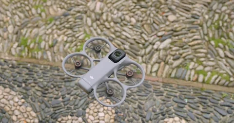 Close Up of Gray FPV Drone Hovering over Cobblestone Ground Stock Footage 343928412