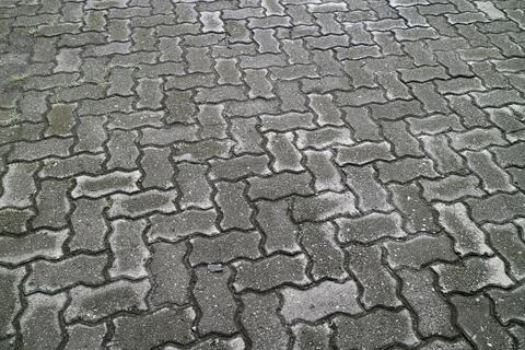 Close up of gray interlocking concrete paving stones with weathered texture.. Stock Photos