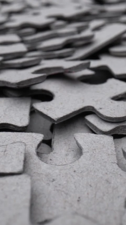 Close-up of gray interlocking jigsaw puzzle pieces with shallow depth of field Stock Footage 341530569