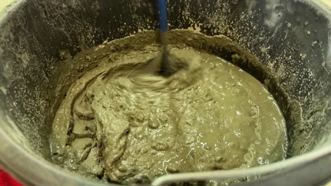 A close-up of gray paint being stirred smoothly in a paint can with stick. 库存影片 331569484