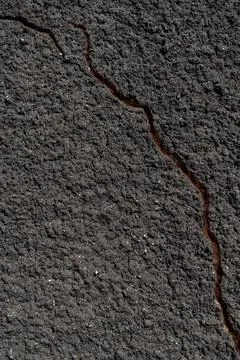 Close-up of a gray wall with a crack. Texture of rough plaster with uneven gr Stock Photos