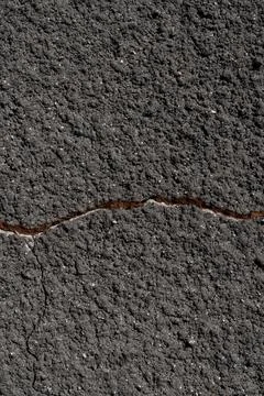 Close-up of a gray wall with a crack. Texture of rough plaster with uneven gr Stock Photos