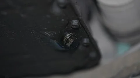 Close-up of a greasy engine oil pan drain plug bolt. Stock Footage 345912798