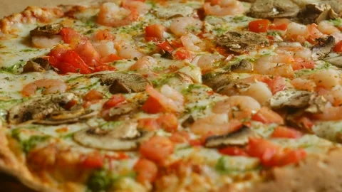 Close-up greasy pizza loaded with shrimp mushrooms and tomatoes unhealthy choice Stock Footage 312847080