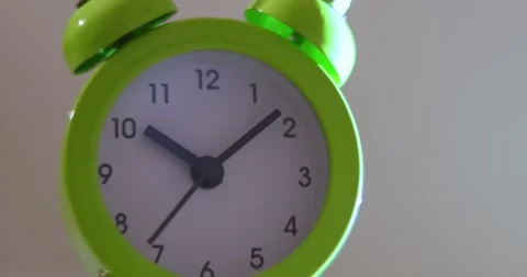 Close up a green alarm clock with a white face showing the time of 10:10 on w Stock-Footage 300364552