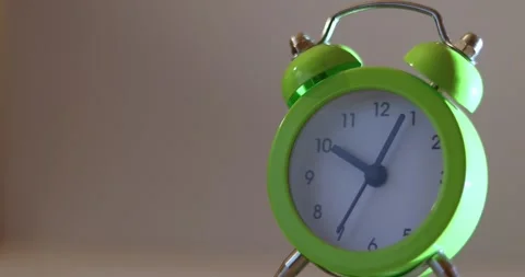 Close up a green alarm clock with a white face showing the time of 10:10 on w Stock-Footage 300364564