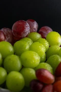 Close-Up of Green and Red Grapes with Water Drops on Black Background Foto stock