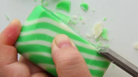 Close-up of green and white striped soap being carved with precision. Stock Footage 313753330