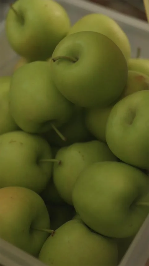 Close up of green apples pouring into crate during harvest Stock Footage 342818828