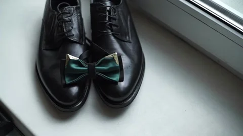 Close-up of green bow tie lying on black classic, leather shoes. Stock Footage 200524497