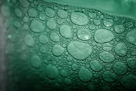 Close-up of green bubbles forming on a liquid surface, creating an abstract p Stock Photos