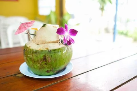 Close up of green coconuts with drinking straw in the restaurant. Foto stock