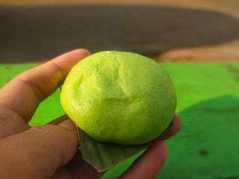 Close up of a green colored bun being held in someone's hand Stock Photos