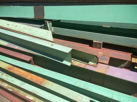 Close up of a green colored, slightly rusty beams stacked in a metal Stock Photos