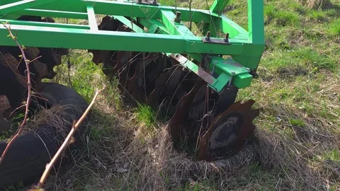 Close-up of a green disc harrow on a field in early spring. Rusty metal dis.. Vídeos de archivo 333790874