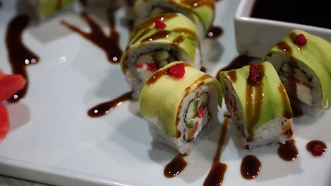 Close up of green dragon roll and place it on a plate or platter set. Stock Footage 87166836