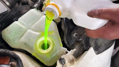 Close Up Of Green Engine Coolant Filling Car Coolant Reservoir During Service Stock Footage 340954819