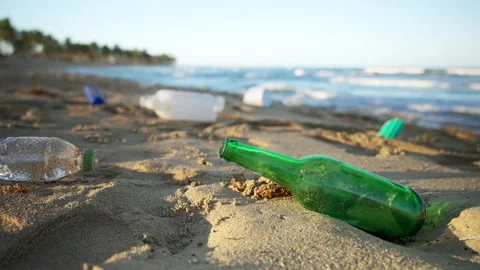 Close-up of green glass empty beer bottle on the sandy beach Stock Footage 169452750