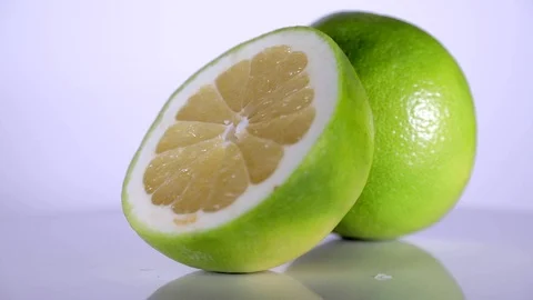 Close up of green lime two slices rotating on table 스톡 동영상 106764041