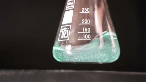 Close-up of green liquid shaking in a flask. Scientific background. Stock Footage 176242693