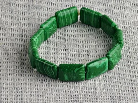 Close-up of green malachite rectangular bead bracelet on burlap background Stock Photos