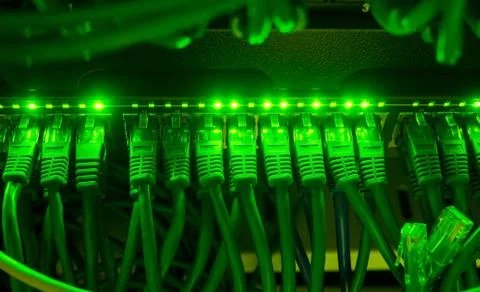 Close up of green network cables connected to switch glowing in the dark Stock Photos