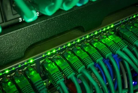 Close up of green network cables connected to switch glowing in the dark Stock Photos