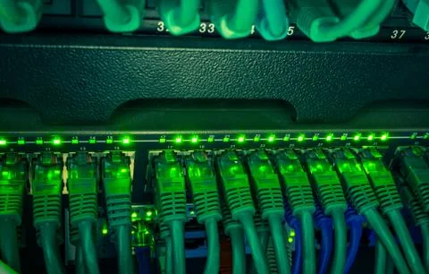 Close up of green network cables connected to switch glowing in the dark Stock Photos
