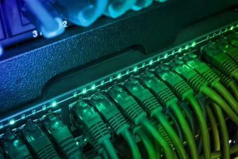 Close up of green network cables connected to switch glowing in the dark Stock Photos