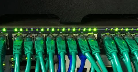 Close up of green network cables connected to switch glowing Stock Photos